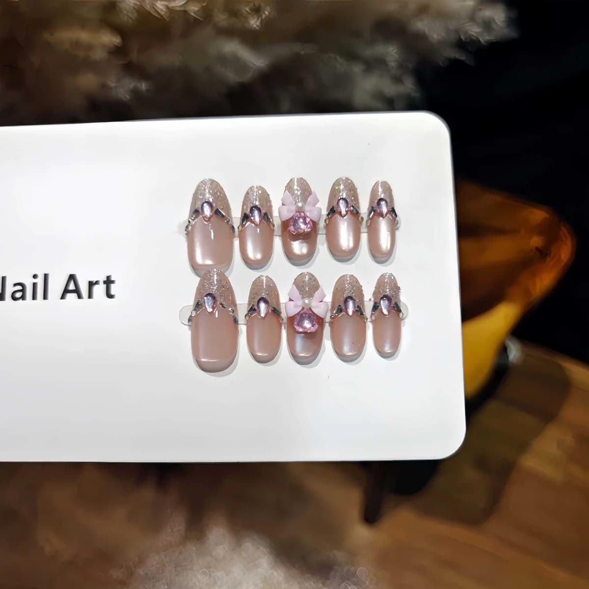 Pinkit kissansilmäliimattavat kynnet, kimalle ja rusettidesign