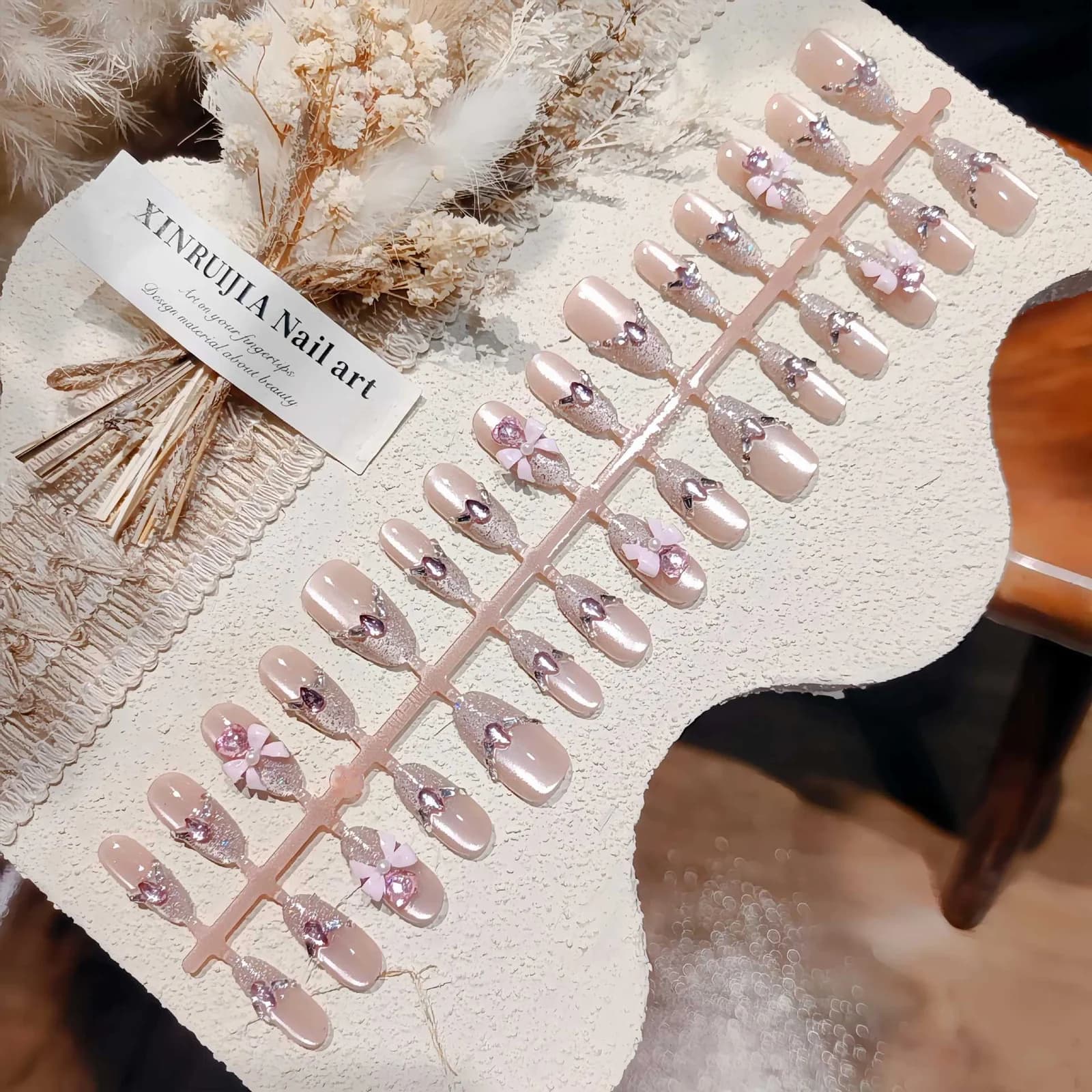 Pinkit kissansilmäliimattavat kynnet, kimalle ja rusettidesign