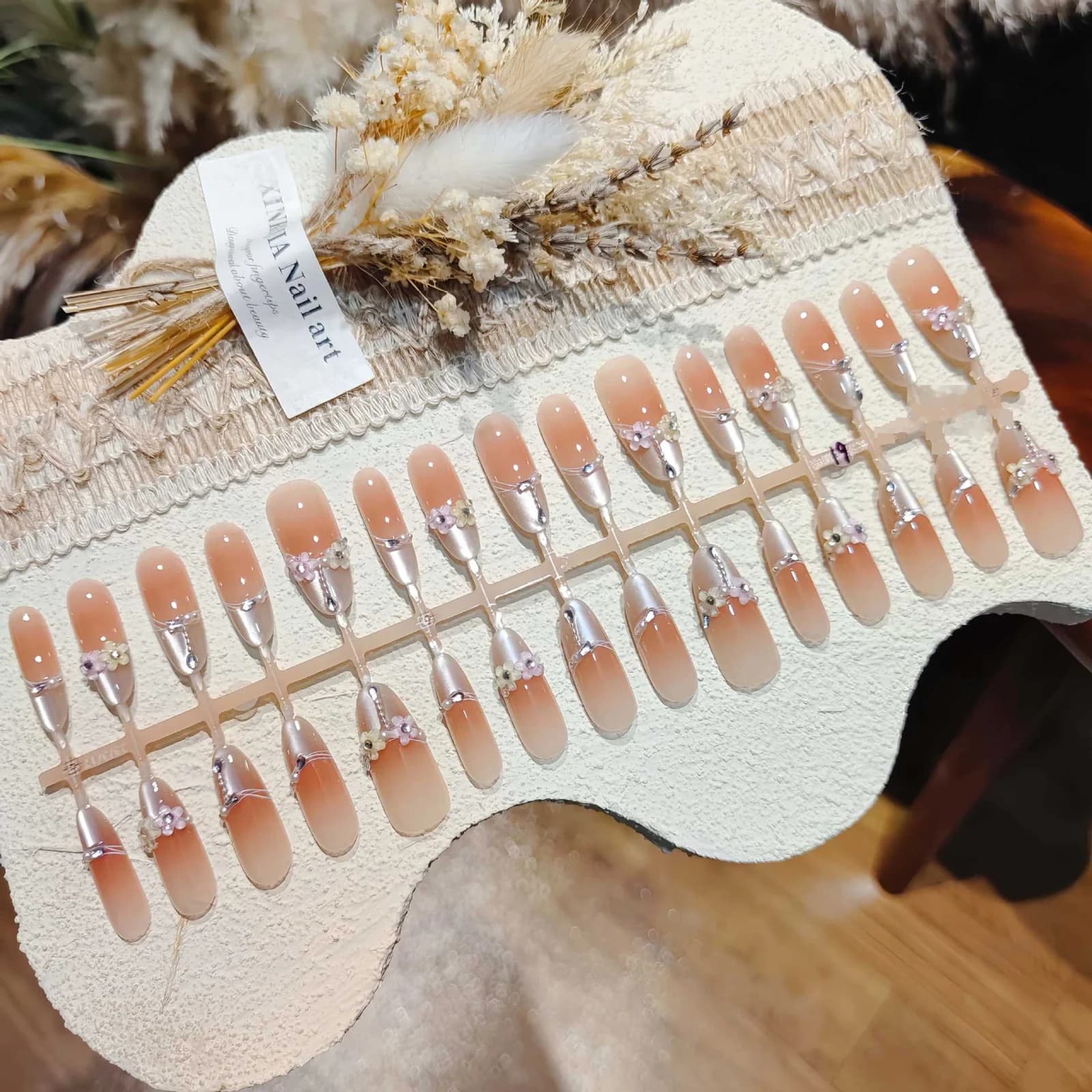 Kukkakuvioiset kissansilmätekokynnet, pitkä stiletto-muoto, kristallikoristein